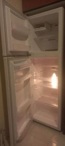 an empty refrigerator with its door open in a kitchen at Stavros House παραθαλάσσια μονοκατοικία in Dhílesi