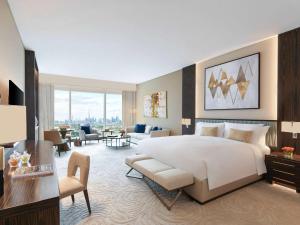a bedroom with a large bed and a living room at Sofitel Dubai The Obelisk in Dubai
