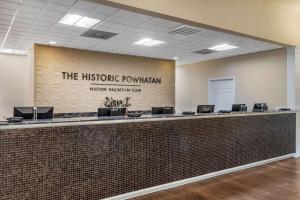 a lobby with a reception counter with a sign on a wall at Hilton Vacation Club The Historic Powhatan Williamsburg in Williamsburg