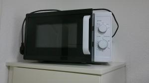 a microwave oven sitting on top of a cabinet at Unseburg Ferienwohnung 1 