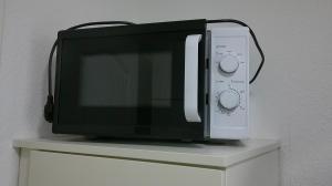 a microwave oven sitting on top of a cabinet at Unseburger Brauhaus GmbH Ferienwohnung 1 in Unseburg