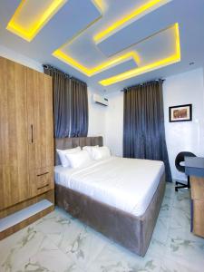 a bedroom with a bed and a desk in a room at Omah Apartments in Abuja