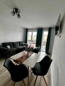 een woonkamer met een tafel en stoelen en een bank bij Boutique Apartments 2 in Sînpetru
