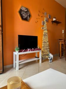 a living room with a christmas tree and a television at ButterflyHouse in Monserrato