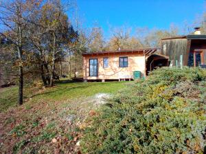 una casa sul fianco di una collina con alberi di maison dans un écrin de verdure a Saint-Léon-sur-Vézère
