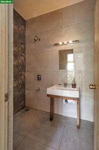 ein Bad mit einem Waschbecken und einem Spiegel in der Unterkunft Jungle stay by Bilwa Estate in SanivÄrsante
