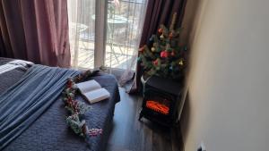 a christmas tree in a bedroom with a fireplace at Nature View Designer Studio in Tsaghkadzor