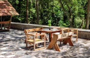 Jungle stay by Bilwa Estate في SanivÄrsante: طاولة وكراسي خشبية على الفناء