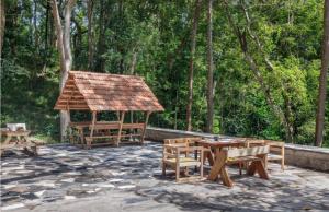 eine Terrasse mit einem Pavillon sowie Tischen und Stühlen in der Unterkunft Jungle stay by Bilwa Estate in SanivÄrsante