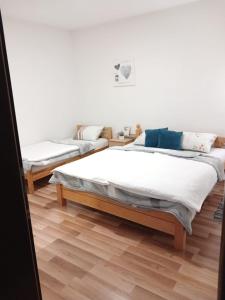Duas camas num quarto com pisos em madeira em Apartman Villa Vita em Capljina