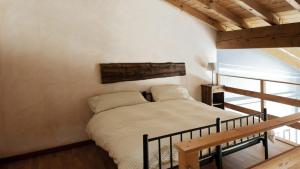 a bedroom with a bed and a wooden staircase at Cascina Clarabella in Iseo