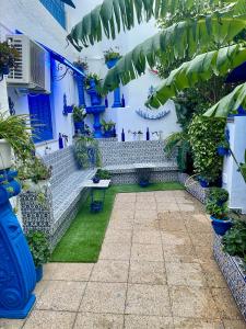 einen Innenhof in einem Haus mit blauen Wänden und Pflanzen in der Unterkunft The Blue and White Perle in Sidi Bou Saïd