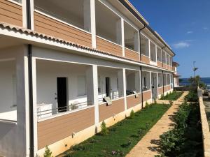 - un bâtiment avec des balcons sur le côté dans l'établissement ApartHotel Capo Rizzuto, à Ovile la Marinella