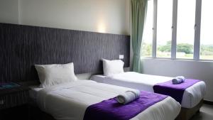 a hotel room with two beds and a window at Salsa Resort Langkawi By Casa Loma in Pantai Cenang