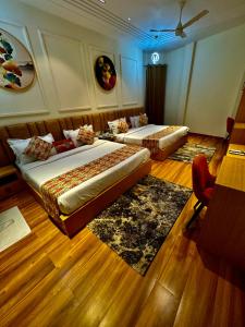two beds in a room with wooden floors at Hotel Heaven View - 50m From Golden Temple in Amritsar