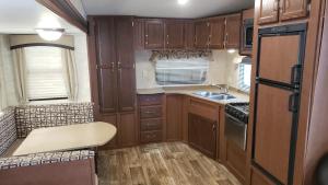 Elle comprend une petite cuisine avec des placards en bois et un évier. dans l'établissement Tiny House RV, Kayak, à Key Largo