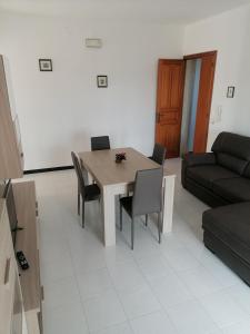 ein Wohnzimmer mit einem Tisch, Stühlen und einem Sofa in der Unterkunft Casa del sole in Montalbano Ionico