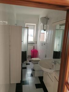 ein Badezimmer mit einem Waschbecken, einem WC und einem Waschbecken in der Unterkunft Casa del sole in Montalbano Ionico