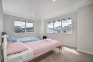 una camera con due letti e due finestre di Extra-Large Brand-New House 8 Bedrooms 6 Bathrooms ad Auckland