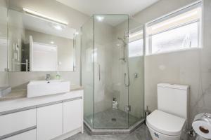 e bagno con doccia, servizi igienici e lavandino. di Extra-Large Brand-New House 8 Bedrooms 6 Bathrooms ad Auckland