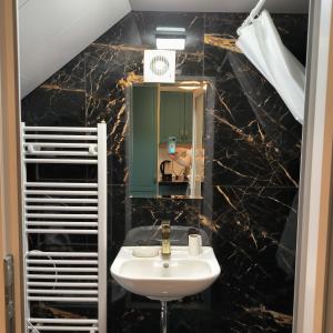 La salle de bains est pourvue d'un lavabo et d'un miroir. dans l'établissement LUBERT APARTMÁNY s.r.o, à Prague