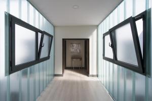 an empty hallway with two windows in a room at Hostal Emeritae in Mérida