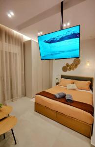 a bedroom with a bed with a flat screen tv on the wall at Elpis' cozy & luxury apartment in Athens