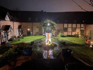 a house with a fountain in a yard at night at The Old Sack Warehouse in Hereford