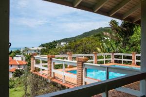 uma varanda com vista para uma piscina em Casa Vista Mar Deslumbrante com Piscina CAN5 em Florianópolis