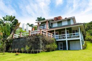 uma casa grande com um quintal verde em Casa Vista Mar Deslumbrante com Piscina CAN5 em Florianópolis