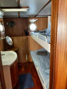 a small room with two bunk beds and a sink at M/S Furusund in Furusund