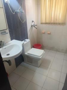 a bathroom with a toilet and a sink at Omaxe eternity in Vrindāvan