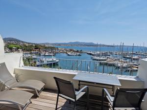 un balcone con sedie, tavolo e porto turistico di Sanaritz a Sanary-sur-Mer