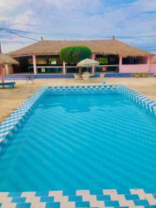 a large blue swimming pool in front of a building at Hotel Toolbi in Niaga