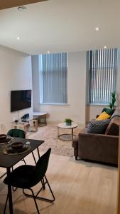 a living room with a couch and a table at Kest Cozy Apartment in Leeds! in Leeds