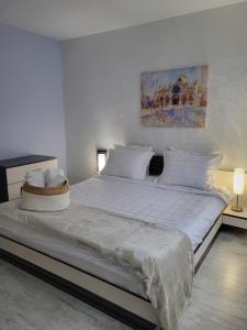 a bedroom with a large bed with white sheets and pillows at Luny apartment in Ruse