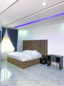 um quarto com uma cama grande e uma secretária em D & D Apartments em Abuja