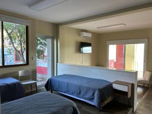 1 dormitorio con 2 camas y TV en la pared en Apart Gallery - San Lorenzo - Salta en Salta