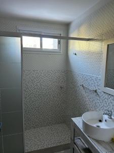 y baño blanco con lavabo y ducha. en Apart Gallery - San Lorenzo - Salta en Salta