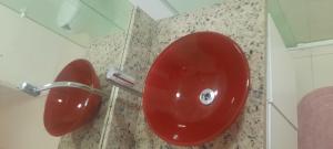 a red toilet seat in a bathroom stall at VS HOSPEDAGEM in Cascavel