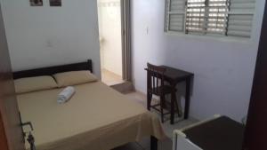 une chambre avec un lit, un bureau et une chaise dans l'établissement La Villa Hotel, à Cordeirópolis