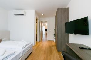 sypialnia z łóżkiem i telewizorem z płaskim ekranem w obiekcie Vienna Stay Apartments Castellez 1020 w Wiedniu
