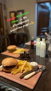 a hamburger and french fries on a wooden cutting board at Mountain View in Synikia Mesi Trikalon