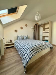 een slaapkamer met een bed met een geruite deken bij Appartement tout confort 60 m² in Haveluy