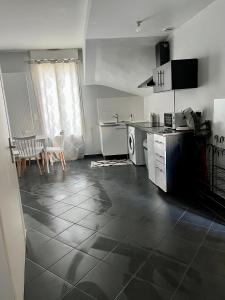 a kitchen with a counter and a table and chairs at Appartement gare RER D maisons alfort Alfortville in Alfortville