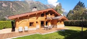 a log cabin with a table and chairs on a deck at Chalet Kidou in Chamonix