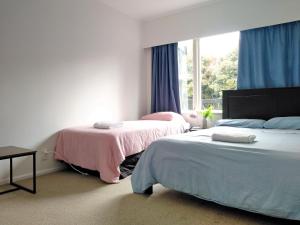 a bedroom with two beds and a window at Large 6BR House South Auckland in Auckland