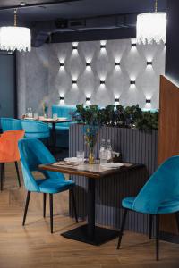 a dining room with a table and blue chairs at Dami Almaty Hotel in Almaty