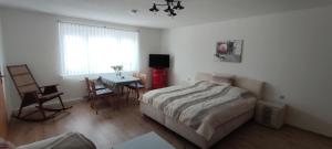 a bedroom with a bed and a table and a window at Ferienwohnung Schulzental in Ilmenau