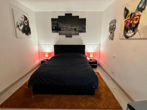 ein Schlafzimmer mit einem schwarzen Bett und zwei Lampen in der Unterkunft Superbe F2 terrasse, route du vin, Florival in Guebwiller